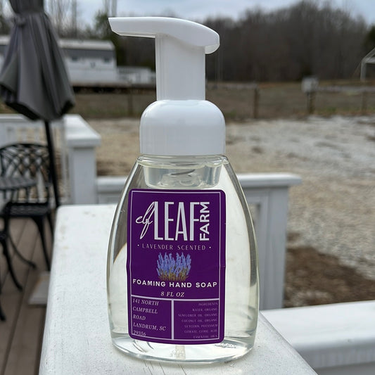 A bottle of foaming hand soap in a clear pump bottle with a purple label.