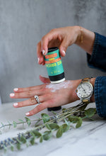Load image into Gallery viewer, A woman applies Bee Bright Sunscreen Stick to the back of her hand.