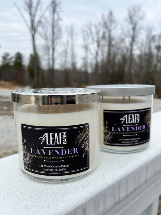 Two white candles with the label "Elf Leaf Farm Lavender Candle" are positioned close to the camera.