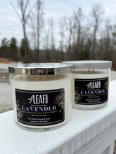 Load image into Gallery viewer, Two white candles with the label "Elf Leaf Farm Lavender Candle" are positioned close to the camera.