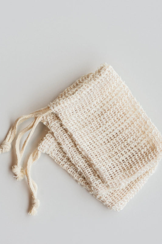 A group of three woven beige soap nets rest on a white background. 