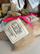 Load image into Gallery viewer, A burlap sack-style bag is positioned close to the camera. It is tied with a bright pink ribbon and a label that reads &quot;Elf Leaf Farm Lavender Rose Scones&quot;.
