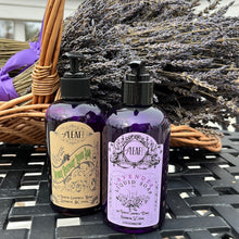 Load image into Gallery viewer, Two purple bottles of Liquid Hand Soap stand in front of a basket of dried lavender. 
