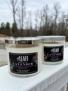 Two white candles with the label "Elf Leaf Farm Lavender Candle" are positioned close to the camera. 
