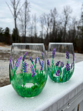 Load image into Gallery viewer, Two stemless wine glasses that have been handpainted with a lavender flower motif. 
