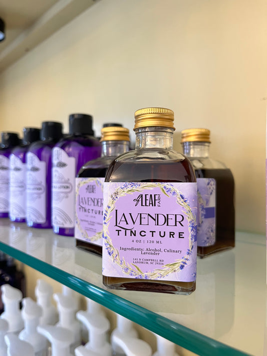 A glass bottle of Elf Leaf Farm Lavender Tincture sits on a glass shelf. 