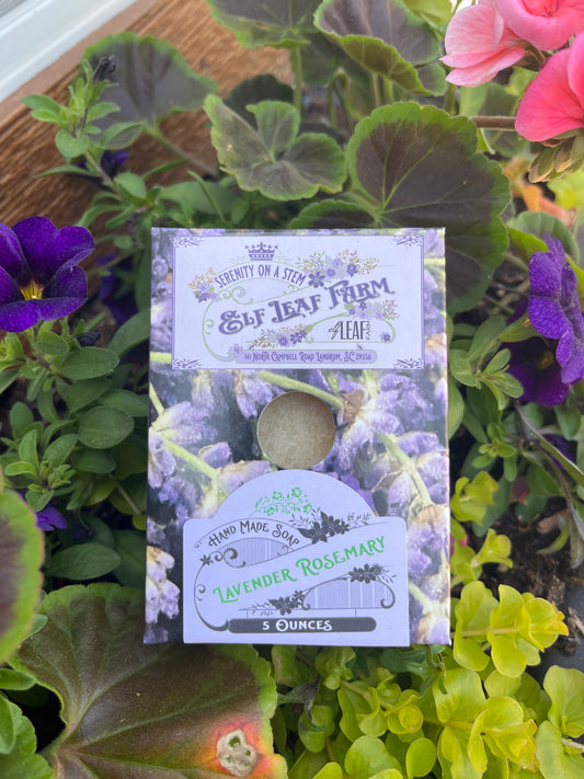 A bar of Elf Leaf Farm Lavender Rosemary Soap sits among fresh flowers. 